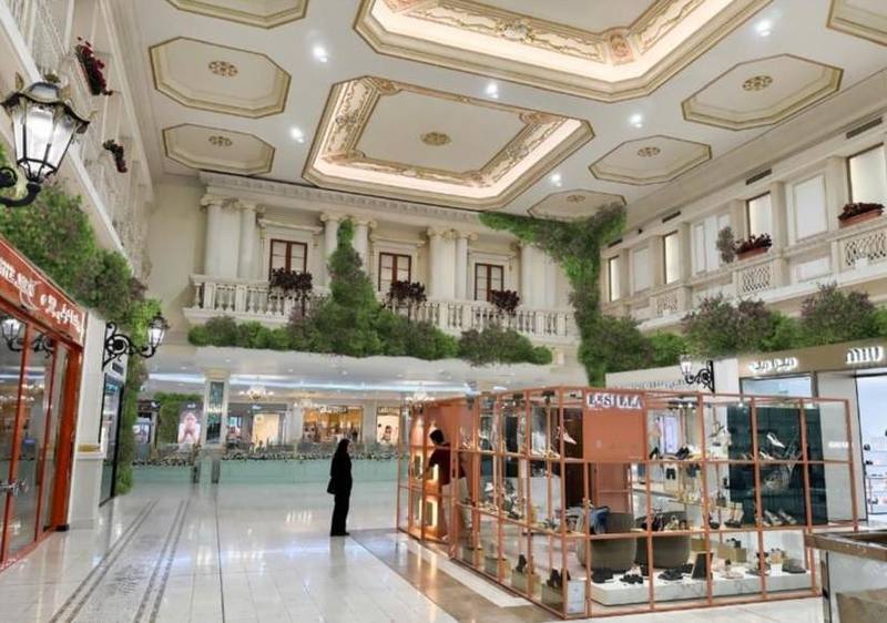 Mall atrium facade with cascading greenery above a fountain